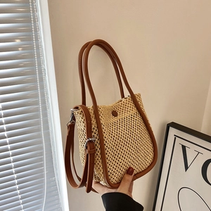 French style woven straw bucket bag with brown leather handles and adjustable strap