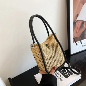 French straw bucket bag with black leather trim and long shoulder strap for women
