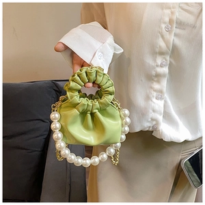 Detail of light green cloud bag with pleated handle and elegant white pearl chain