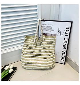 Close-up of hand-woven striped knit tote bag with adjustable white leather handles
