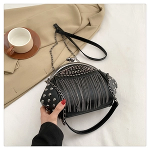Detailansicht der schwarzen Retro-Tasche mit silbernen Nieten und Metall-Quasten
