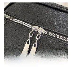 Detailed macro view of smooth silver dual metal zippers on black lychee texture leather