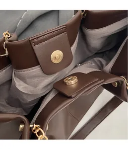 Nahaufnahme braune Ledertasche mit goldenem Magnetverschluss und feinen Nähten