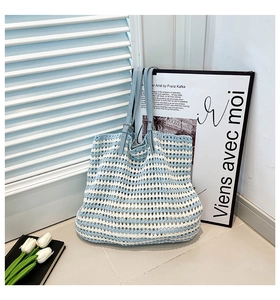 Detail of hand-woven crochet tote bag featuring light blue stripes and hollow mesh texture