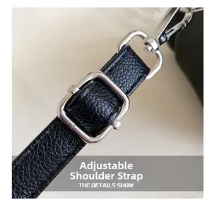 Detail of adjustable black leather strap with silver buckle and hook on a crossbody bag