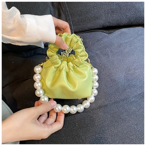 Detail of lime green mini cloud bag with ruched texture and elegant pearl handle