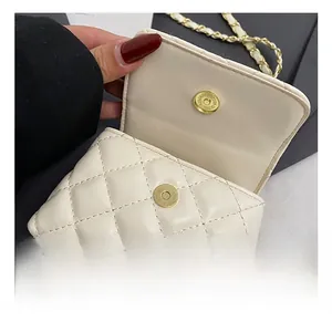 Close-up of beige quilted mini bag with gold magnetic buckle and metal chain strap