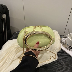 Light green patent leather mini clutch with large gold ring handle and snake chain strap