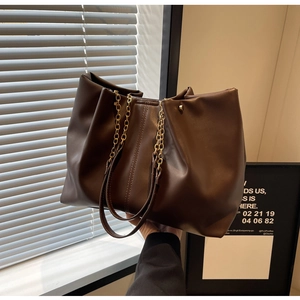 Detailansicht der großen dunkelbraunen Leder-Shopper mit Kettenriemen und weicher Textur