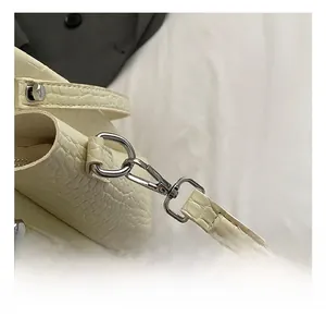 Close-up of high-quality silver metal hook and cream crocodile pattern leather strap