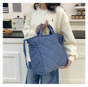 Sac fourre-tout bleu matelassé à losanges présenté dans un décor de cuisine chic