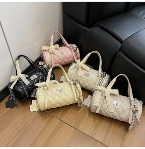 Quilted cylindrical bags in various colors with lace bows and chain handles