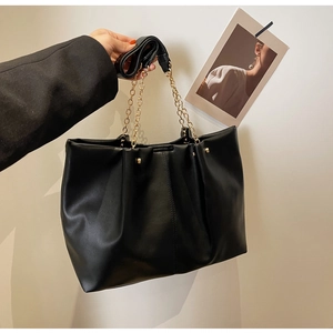 Detailansicht der schwarzen PU-Ledertextur und goldenen Kette der großen Tote Bag