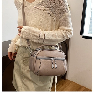 Close-up of a light purple pebbled leather bag with silver zippers and elegant texture