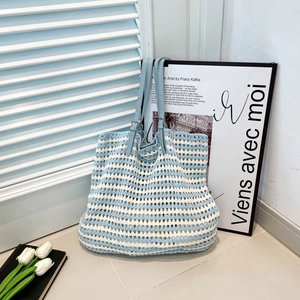 Handwoven blue and white striped crochet tote bag with adjustable leather straps for beach