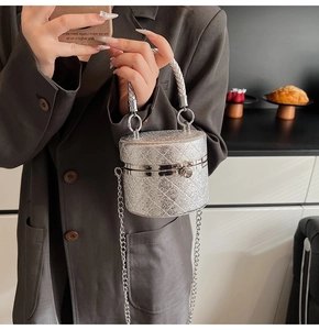 Detail der silbernen Pailletten-Eimertasche mit Stepptextur und Webgriff