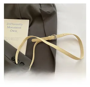 Detail of adjustable beige faux leather shoulder strap with silver metal buckle on a bag