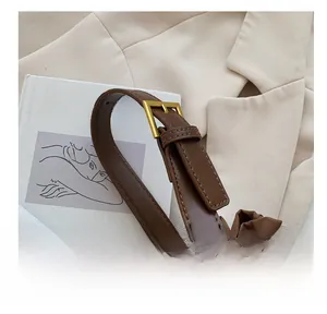 Détail de la bandoulière en cuir marron réglable avec boucle dorée sur le sac à main