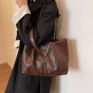 Minimalistische dunkelbraune Oversize-Tasche mit Goldkette und mattem Leder-Finish