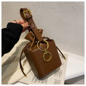 Détail du sac seau marron foncé avec anneau doré et bandoulière réglable