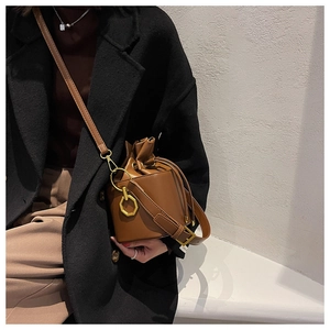 Détail du sac seau marron vintage avec boucles dorées et fermeture par cordon de serrage