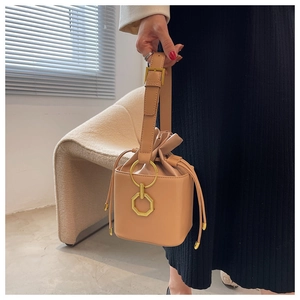 Détail du sac seau marron avec ferrures dorées géométriques et fermeture à cordon