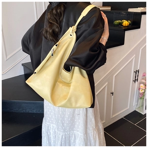 Detail of a yellow oversized soft PU leather tote bag with unique knot shoulder strap