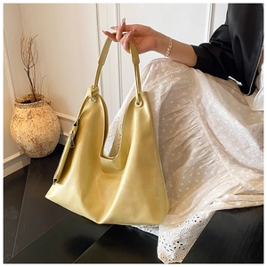 Close-up of mustard yellow PU leather tote bag with unique knotted strap detail