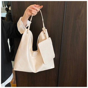Detail of cream PU leather tote bag with adjustable knotted strap and mini matching pouch