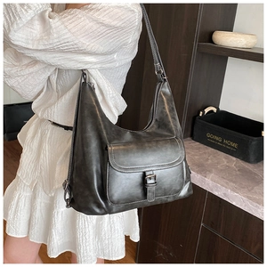 Detailed side view of dark grey hobo bag featuring a metal buckle pocket and leather texture