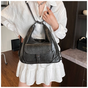 Detail of vintage black leather bag featuring white contrast stitching and metal buckle