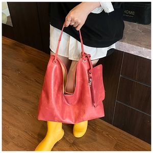 Detail view of large matte red PU leather tote bag with matching zippered charm pouch