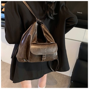 Detail of vintage dark brown faux leather backpack with metallic buckle and retro finish