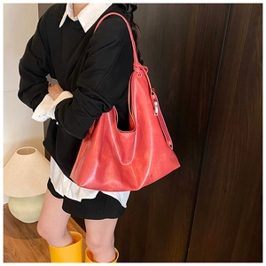 Detail of red PU leather tote bag showing soft texture and side zipper decoration