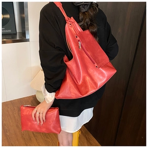 Close-up of vibrant red textured tote bag and matching clutch with knotted strap detail