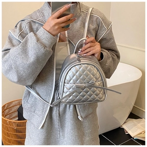 Nahaufnahme des silbernen gesteppten Mini-Rucksacks mit Schleife und Metallic-Optik