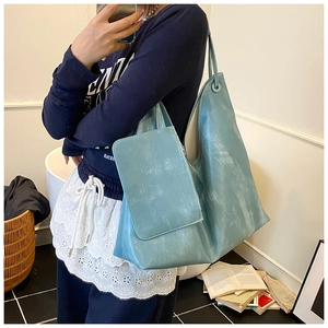 Detail of light blue tote bag in matte PU material with detachable small pouch and strap