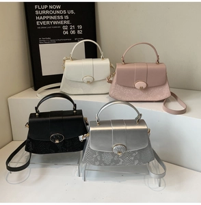 Detailed close-up showing four elegant glossy handbags with snake skin texture and metal M buckle