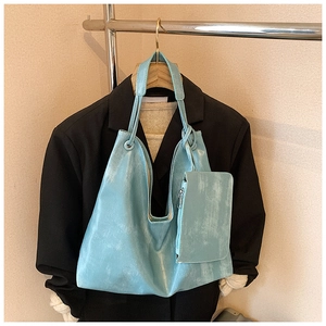 Close-up of light blue PU leather tote bag with matching zippered pouch on hanger