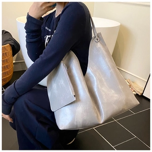 Silver metallic tote bag and matching pouch shown on shoulder for daily commute