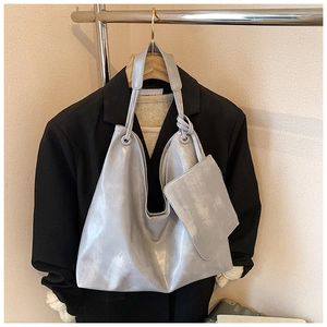 Detailed view of silver PU leather tote bag with matching inner pouch and knot strap