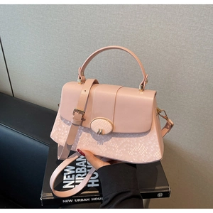 Detail of light pink shoulder bag with snakeskin texture and golden M buckle