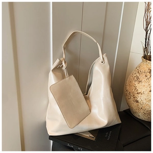 Detail of cream leather hobo tote with matching pouch set and minimalist wide shoulder strap