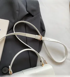 Detail showing white leather shoulder bag with adjustable strap and gold hardware