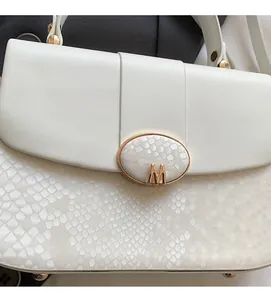 Detailed close-up of white python texture skin and golden M logo metal buckle