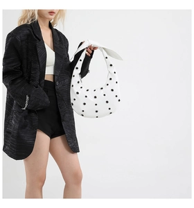 White crescent leather shoulder bag with silver eyelet studs and knotted strap detail