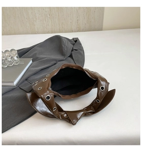 Top view of brown crescent shoulder bag showing interior space and silver metal eyelets