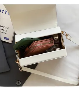 Internal view of white crossbody box bag showing interior capacity with wallet and phone