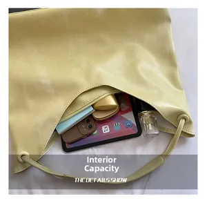 Detail view of the large capacity interior with tablet and cosmetics inside a PU tote bag
