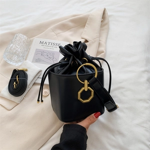Sac seau vintage en cuir noir avec cordon de serrage et boucle dorée sur tissu